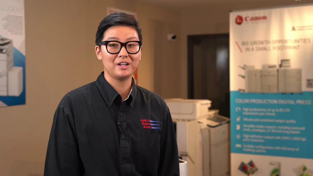 American Business Machines team member speaking in a print-equipment showroom