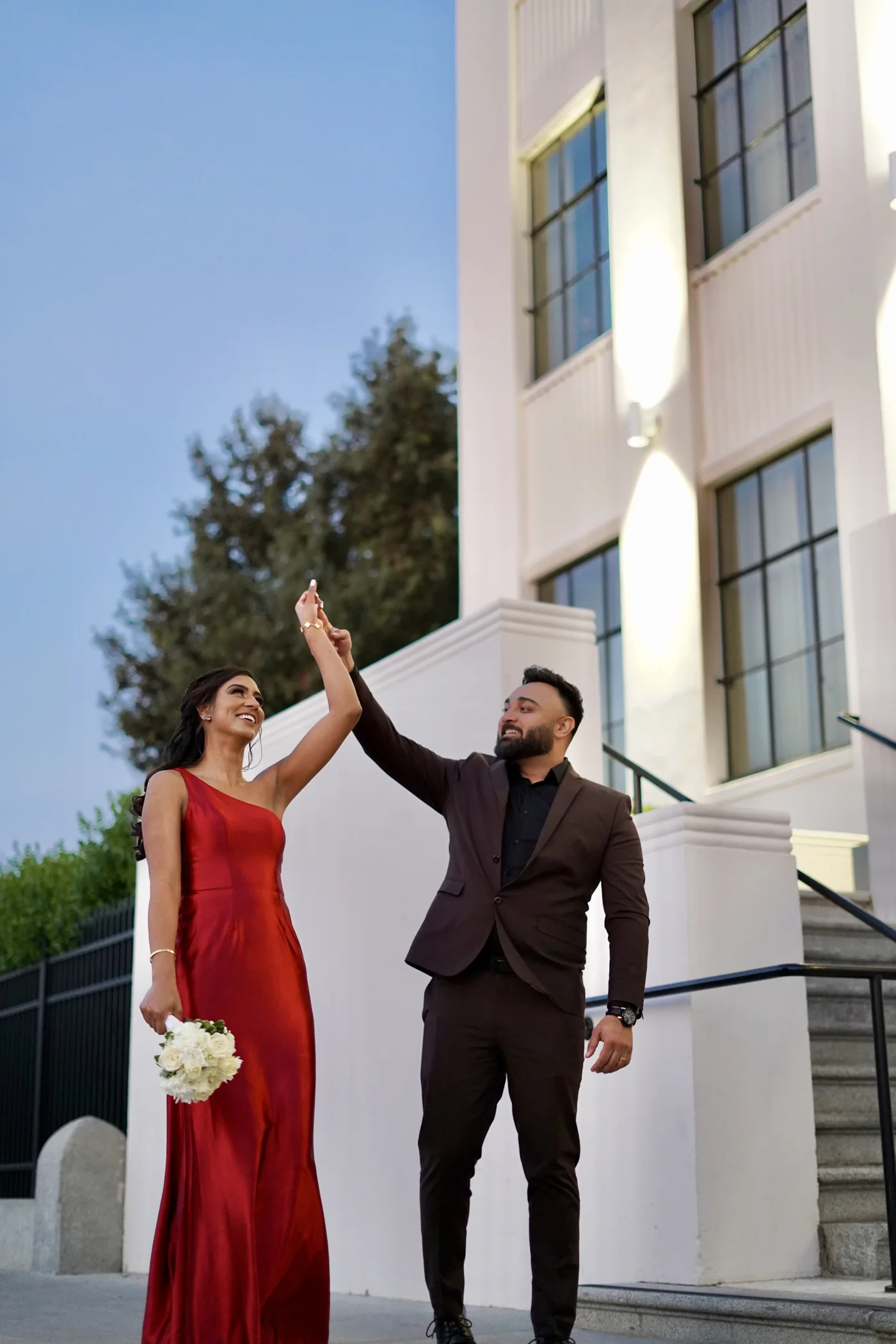 A couple dancing outside a modern white building