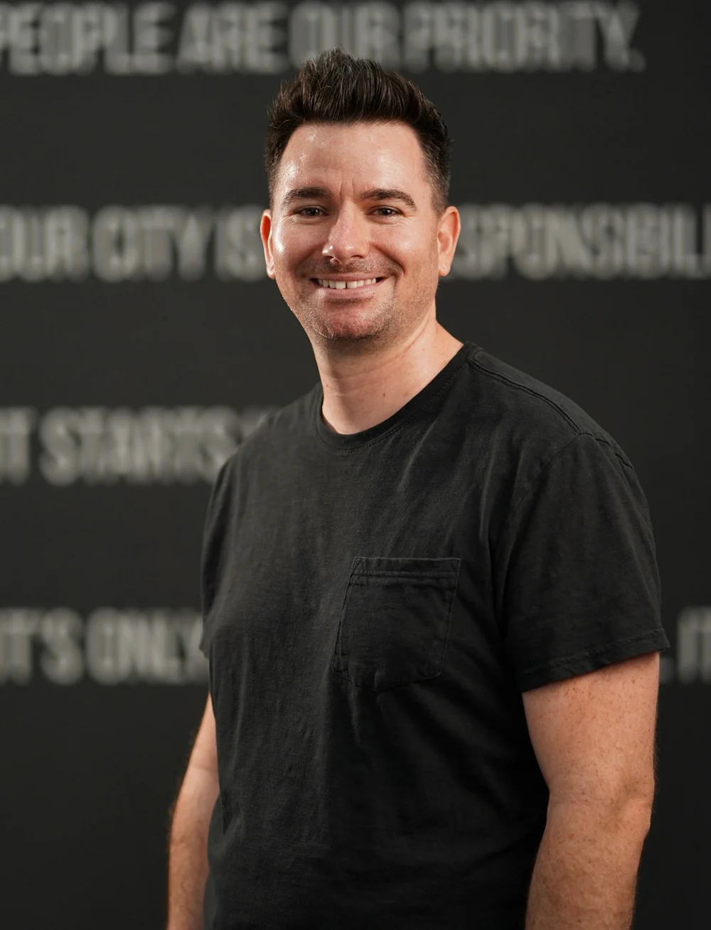Kendel, founder of Q|R Media Co., smiling in a black shirt
