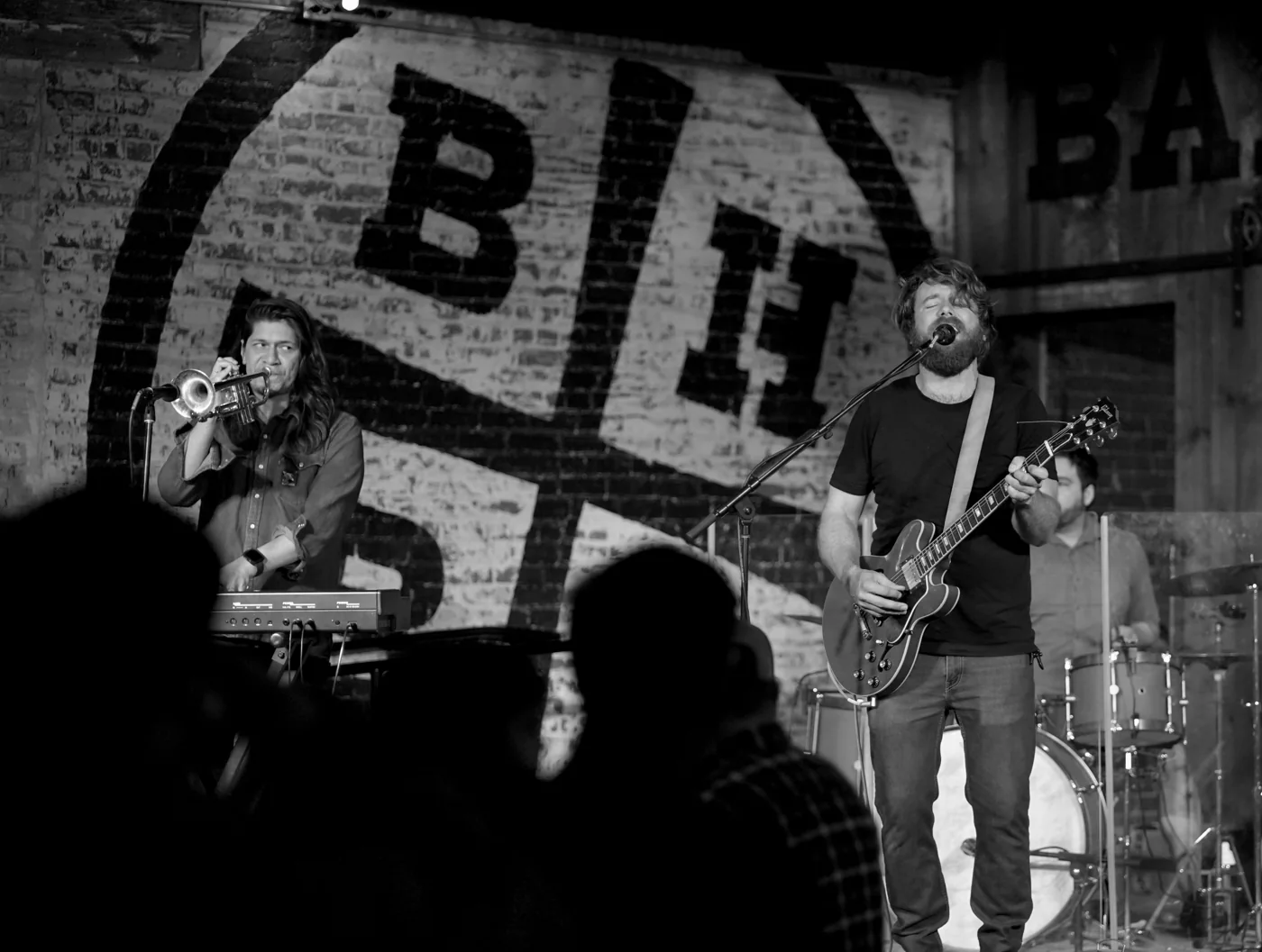 Black-and-white photograph of a band performing in front of an audience