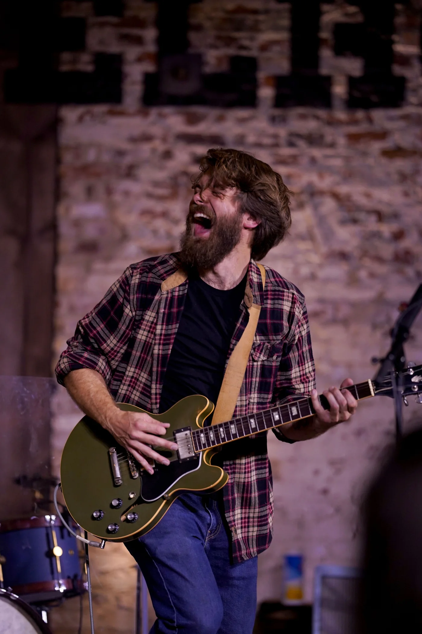 A guitarist playing under warm stage lights